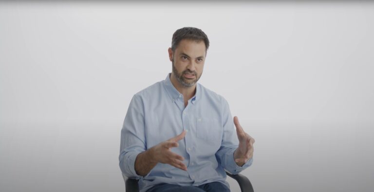 Cena do documentário Bitcoin Brasil com entrevistas e gráficos sobre criptomoedas.